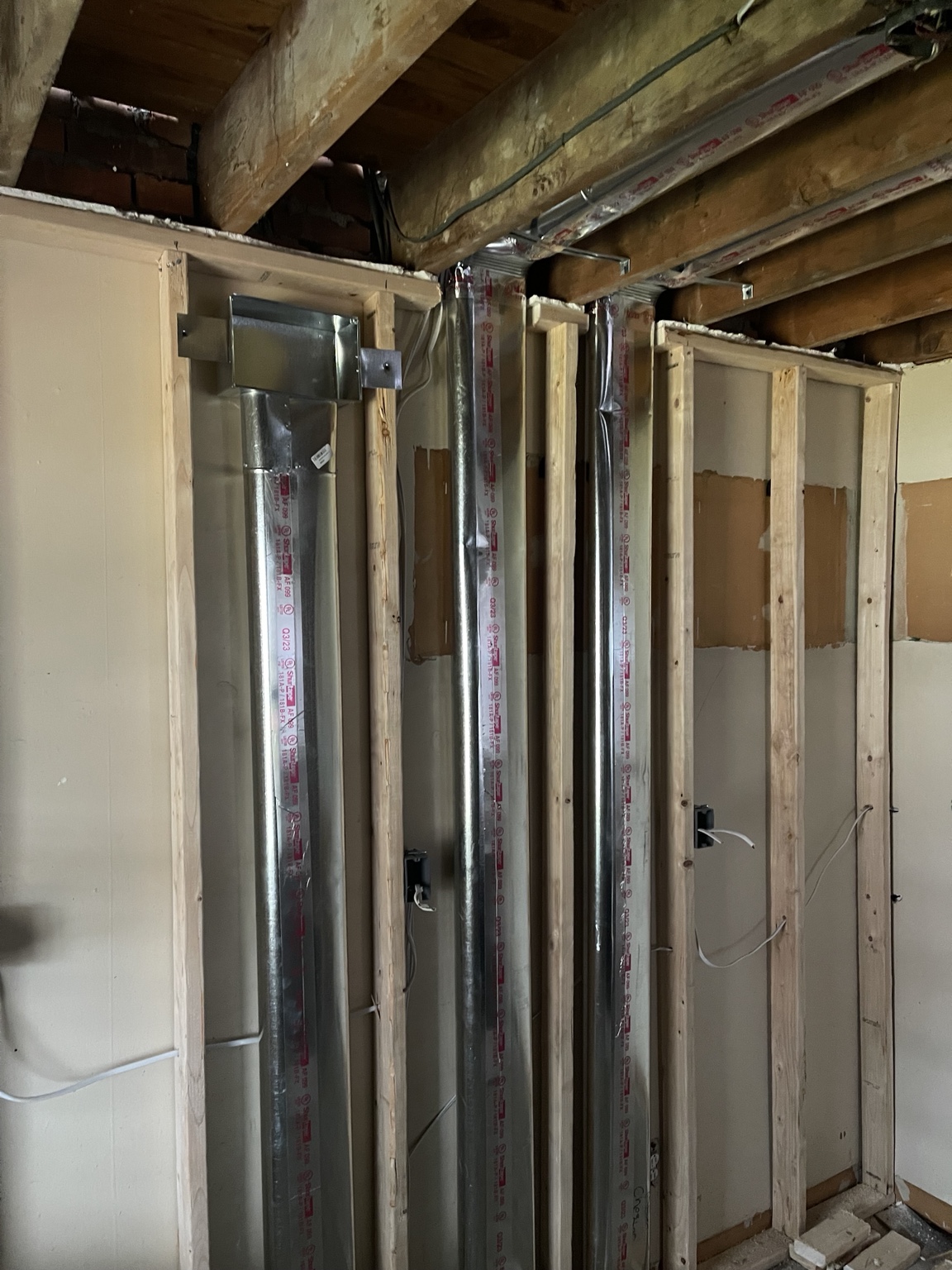 New vertical metal ductwork installed in wall framing